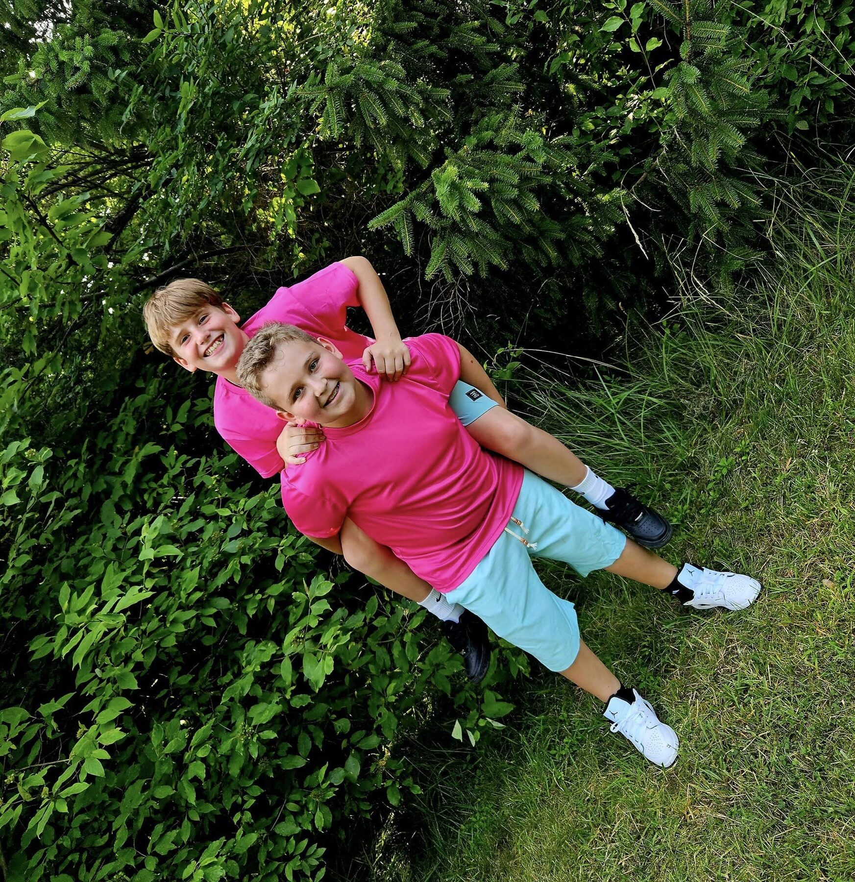 Brothers laughing together in tall summer greenery